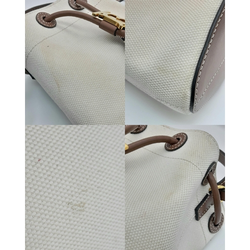 608 - A Burberry Ivory TB Mini Bucket Bag. Canvas exterior with gold-toned hardware, leather trim, adjusta... 