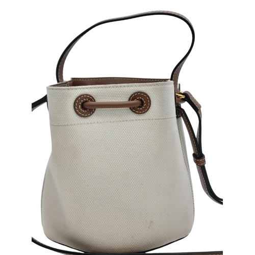 608 - A Burberry Ivory TB Mini Bucket Bag. Canvas exterior with gold-toned hardware, leather trim, adjusta... 