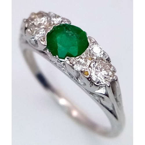 1328 - An 18K White Gold Emerald and Diamond Ring. 0.50ct Emerald with diamond accents. Size M. 3.4g total ... 