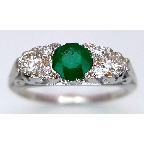 1328 - An 18K White Gold Emerald and Diamond Ring. 0.50ct Emerald with diamond accents. Size M. 3.4g total ... 