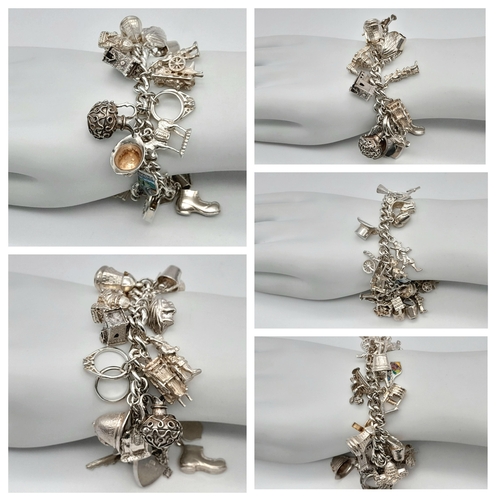 457 - A Sterling Silver Charm Bracelet with Heart Clasp. 25 charms, including: windmill, 21 key and cherub... 