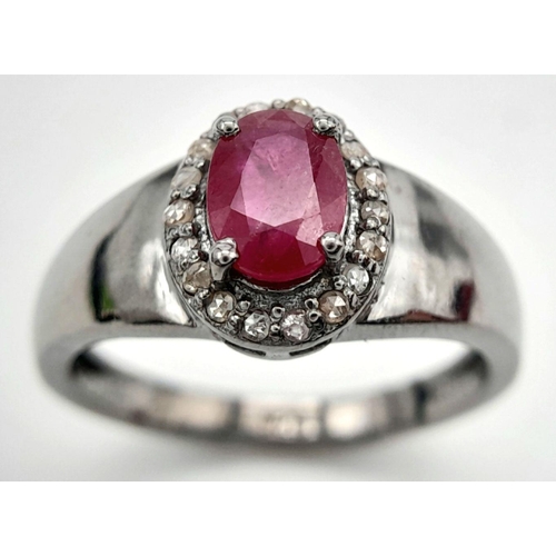 1341 - A 925 Silver with Black Rhodium Ruby Diamonds Ring. A 0.90ct oval-cut Ruby at its center, surrounded... 