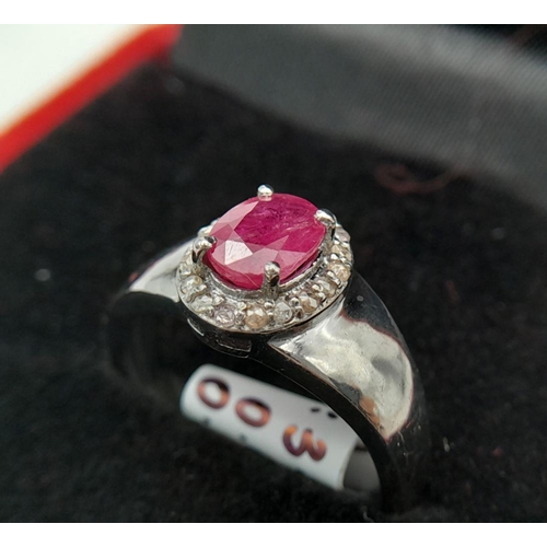 1341 - A 925 Silver with Black Rhodium Ruby Diamonds Ring. A 0.90ct oval-cut Ruby at its center, surrounded... 