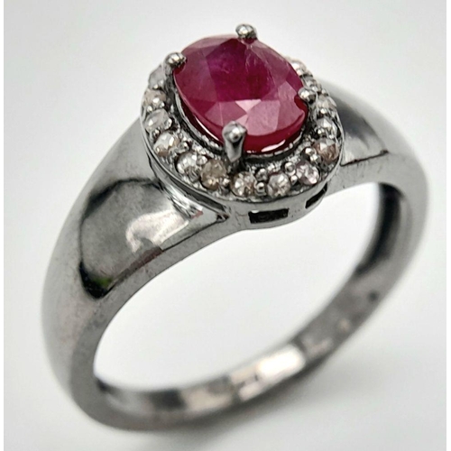 1341 - A 925 Silver with Black Rhodium Ruby Diamonds Ring. A 0.90ct oval-cut Ruby at its center, surrounded... 