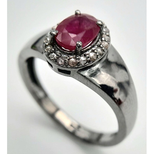 1341 - A 925 Silver with Black Rhodium Ruby Diamonds Ring. A 0.90ct oval-cut Ruby at its center, surrounded... 