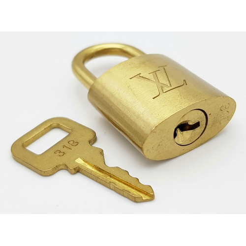 170 - A Louis Vuitton Case Lock and Key. Gilded metal. LV monogram. Good condition.