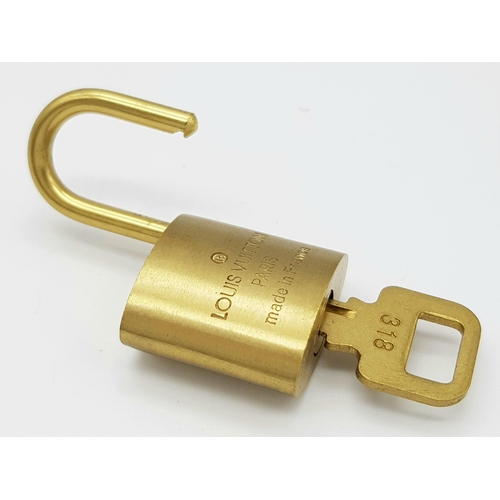 170 - A Louis Vuitton Case Lock and Key. Gilded metal. LV monogram. Good condition.