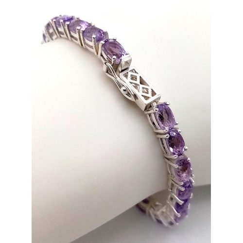 1390 - A 925 silver amethyst gemstone tennis bracelet. Oval-cut amethyst stones. Total length: 18.6cm. Tota... 