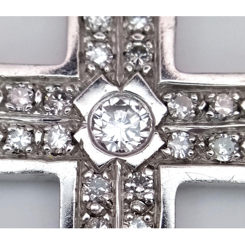 1312 - A 9K White Gold (tested) Diamond Cross Pendant. 0.5ct central brilliant round cut diamond with a fur... 