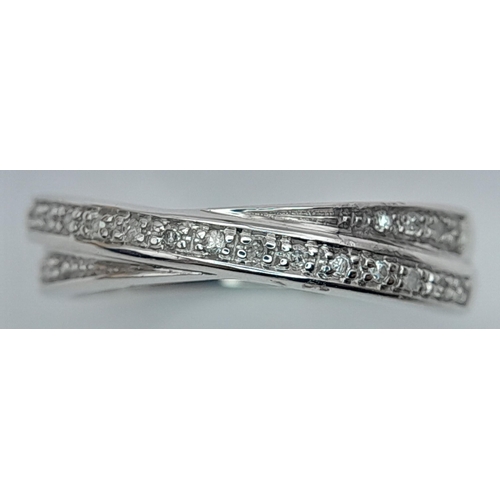 291 - A 9K WHITE GOLD DIAMOND SET CROSSOVER RING 2.7G TOTAL WEIGHT, SIZE M 1/2. Ref: SC 2014