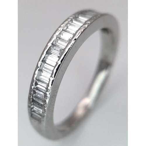 61 - A PLATINUM AND DIAMOND HALF ETERNITY RING. BAGUETTE CUT DIAMONDS - 0.65CTW. 4.3G. SIZE L. JRS1001.