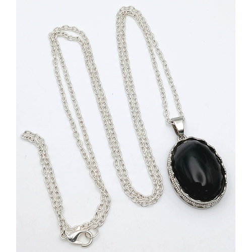 1663 - A Black Agate suite comprising a cuff, a pendant on chain, and a ring. Approx. measurements: ring si... 