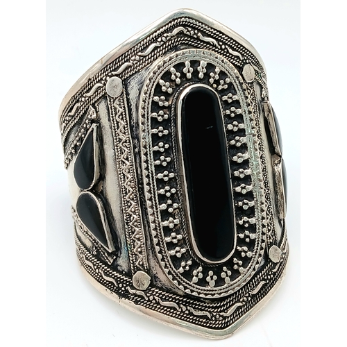 1663 - A Black Agate suite comprising a cuff, a pendant on chain, and a ring. Approx. measurements: ring si... 