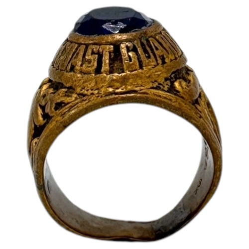 1330 - A Vietnam war era US Coast Guard fraternity Ring, featuring a central dark blue oval stone and a sta... 