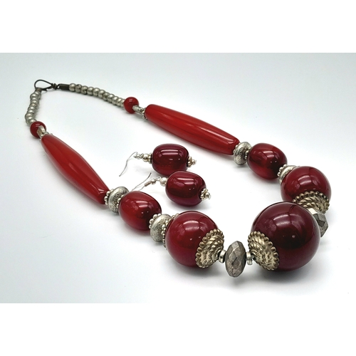 1544 - A cherry resin jewellery suite featuring a bold necklace with graduated cherry resin beads accented ... 