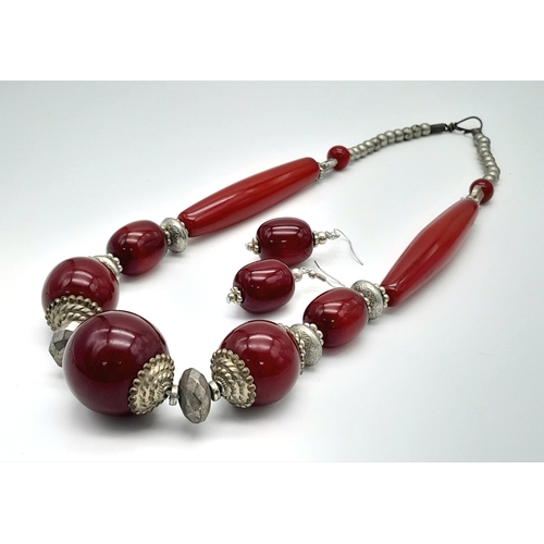 1544 - A cherry resin jewellery suite featuring a bold necklace with graduated cherry resin beads accented ... 