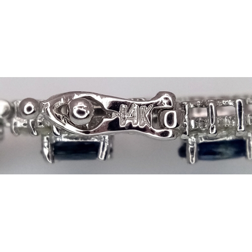 663 - A Beautiful 14K White Gold, Sapphire and Diamond Bracelet. Seventeen oval cut sapphires each with a ... 