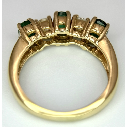 121 - A Mesmerising 14K Yellow Gold Emerald and Diamond Ring. 0.75ctw of oval cut emeralds alternate with ... 