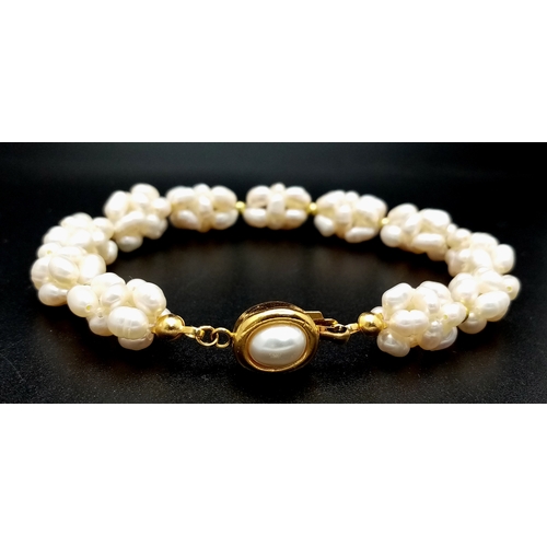 125 - A very feminine, unusual bracelet, with white cultured pearls forming eleven oval groups. Length: 19... 