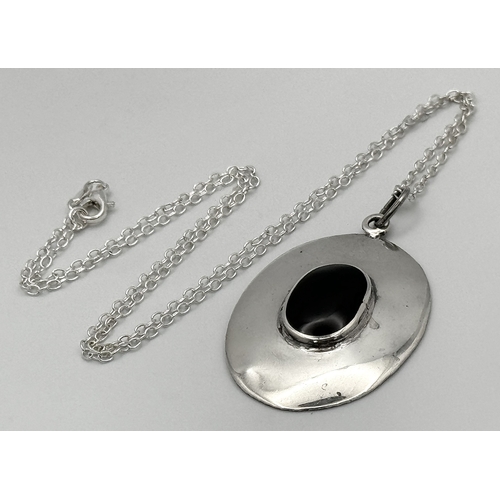 188 - A sterling silver oval pendant with a black onyx cabochon on a sterling silver chain (length: 50 cm)... 