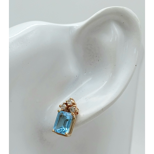 36 - A Head-Turning 18K Gold, Blue Topaz and Diamond Pendant and Earring Set. A 10ct princess cut ice blu... 