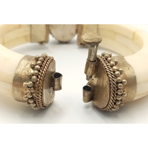 97 - A vintage, North African, white metal bangle constructed with camel (?) bone and adorned with an ova... 