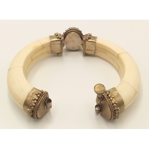 97 - A vintage, North African, white metal bangle constructed with camel (?) bone and adorned with an ova... 