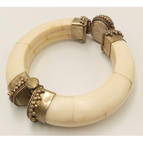 97 - A vintage, North African, white metal bangle constructed with camel (?) bone and adorned with an ova... 