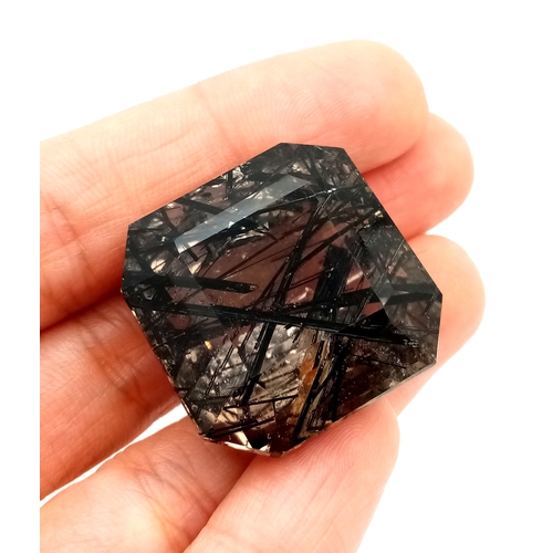 1153 - A 105.53ct Ludwigite-vonsenite quartz, step cut, colourless with black needles, origin: Pakistan. 27... 