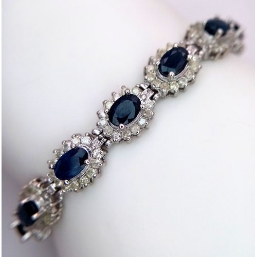 663 - A Beautiful 14K White Gold, Sapphire and Diamond Bracelet. Seventeen oval cut sapphires each with a ... 