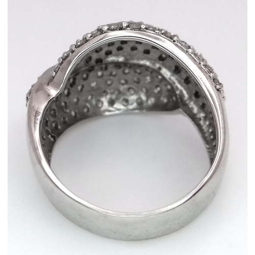 379 - An 18K White Gold Diamond Crossover Pave Ring. Size M. 7.25g total weight.