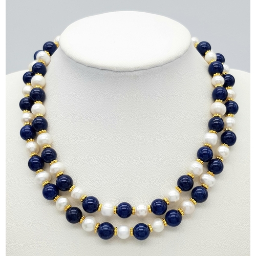 296 - A Lapis Lazuli and Cultured Pearl Matinee Length Necklace. 7/8mm pearls and lapis beads. Gilded spac... 