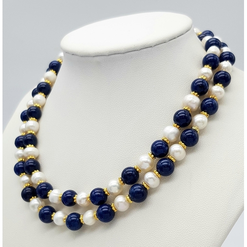 296 - A Lapis Lazuli and Cultured Pearl Matinee Length Necklace. 7/8mm pearls and lapis beads. Gilded spac... 