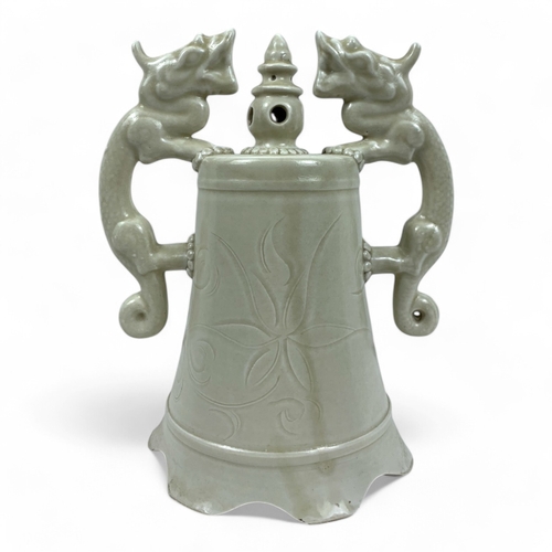 1051 - An antique Chinese Ming dynasty Celadon Green Ceramic Bell. Twin dragon-shaped handles and flared ri... 