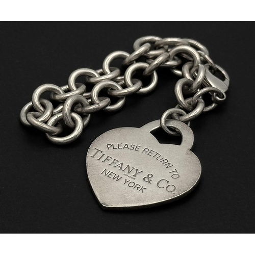 48 - A Brilliant Silver Mix: A Gucci Dog Tag Pendant - 4.5cm. A Tiffany and Co. Bangle - 6cm inner diamet... 