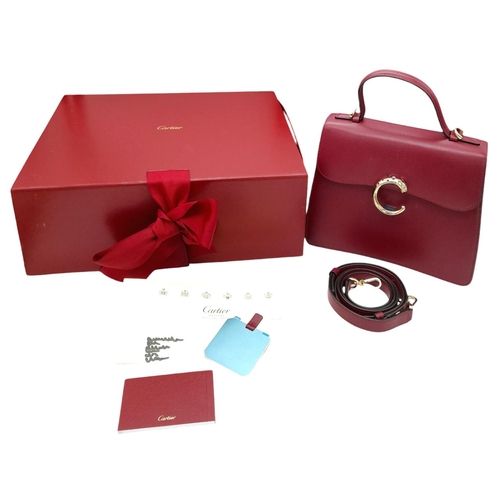 104 - A Panthère de Cartier Handbag. Crafted from poppy red calfskin leather with gold-toned hardware. Fea... 