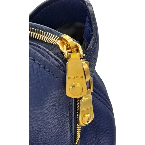 328 - A Miu Miu Vitello Caribu Top Handle Bag. Blue leather exterior with gold-toned hardware, double stra... 