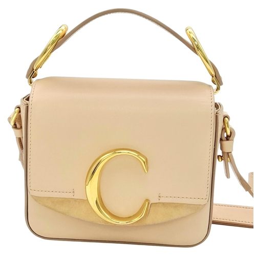 476 - A Chloé Pink C Crossbody Bag. Pink calf leather exterior with a beige suede panel near the gold-tone... 