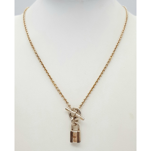 552 - An Hermes 'Kelly' Gilded 925 Silver Padlock Pendant on Gilded Silver Chain. 2cm and 40cm. 11.4g. Com... 