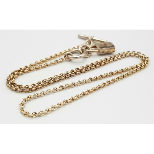 552 - An Hermes 'Kelly' Gilded 925 Silver Padlock Pendant on Gilded Silver Chain. 2cm and 40cm. 11.4g. Com... 