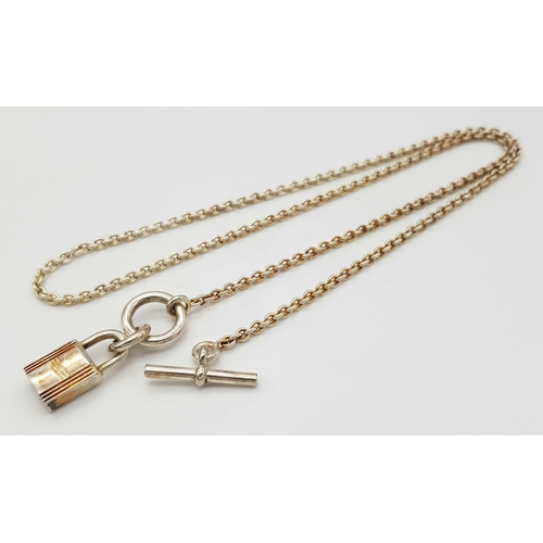 552 - An Hermes 'Kelly' Gilded 925 Silver Padlock Pendant on Gilded Silver Chain. 2cm and 40cm. 11.4g. Com... 