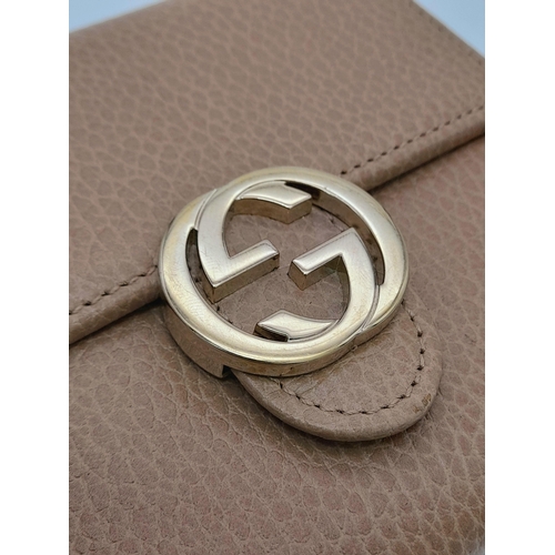 952 - A Gucci Brown Bifold Purse/Wallet. Gold-toned hardware with interlocking G logo and press stud closu... 