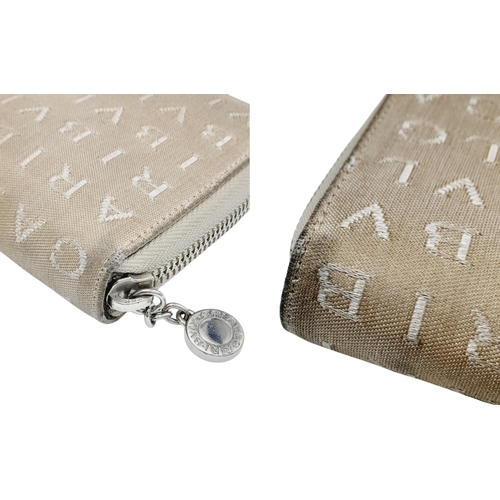 1043 - A Bvlgari Beige Mania Purse. Textile exterior with silver-toned hardware and zip top closure. Brown ... 