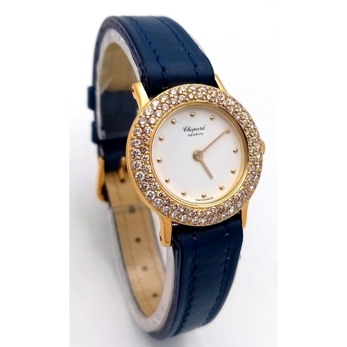 79 - An 18K Gold and Diamond Chopard Ladies Quartz Watch. Blue leather strap. 18k gold case with two halo... 