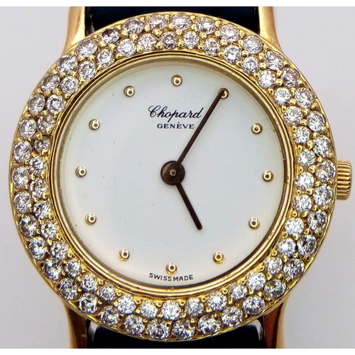 79 - An 18K Gold and Diamond Chopard Ladies Quartz Watch. Blue leather strap. 18k gold case with two halo... 