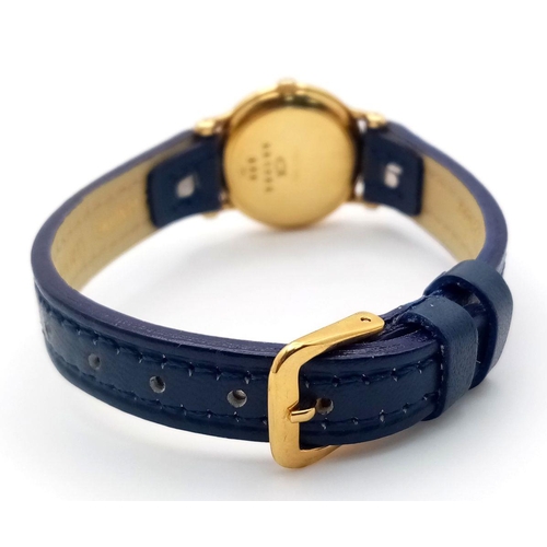 79 - An 18K Gold and Diamond Chopard Ladies Quartz Watch. Blue leather strap. 18k gold case with two halo... 