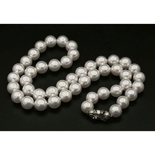 673 - A Beautiful Pastel Tint Pearl Necklace with an 18K Gold and Three Diamond Clasp. Pearls 7/8mm. 0.30c... 