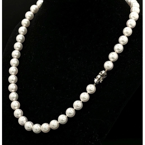 673 - A Beautiful Pastel Tint Pearl Necklace with an 18K Gold and Three Diamond Clasp. Pearls 7/8mm. 0.30c... 