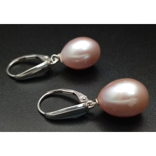 1645 - A Pair of 14K Gold Pastel Pink Pearl Earrings. Large oval pearls - 12mm. 4.8g total weight.