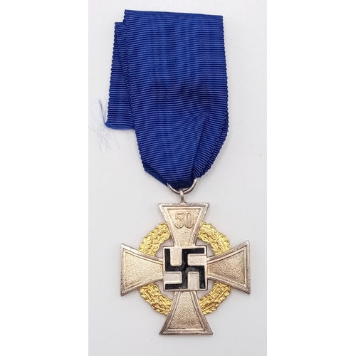 194 - A 3rd Reich 50-year Faithful Service Medal. The enamel to the central swastika undamaged. Slight ton... 